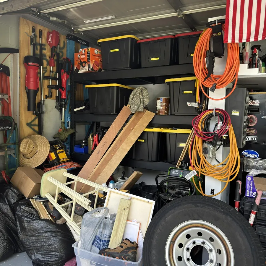 Garage packed with tools, bins and junk before an Eco Haul cleanout