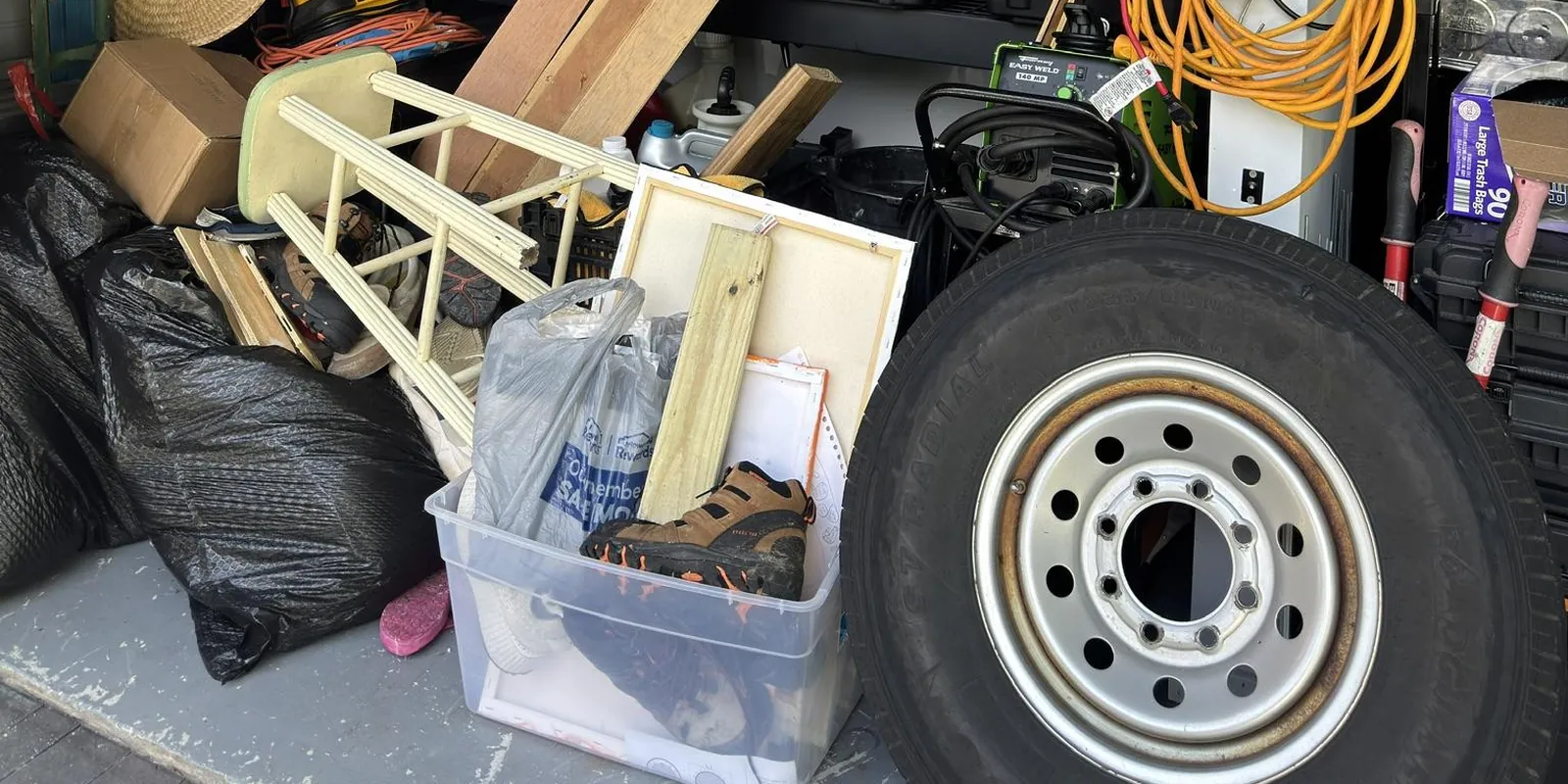 Garage packed with tools, bins and junk before an Eco Haul cleanout