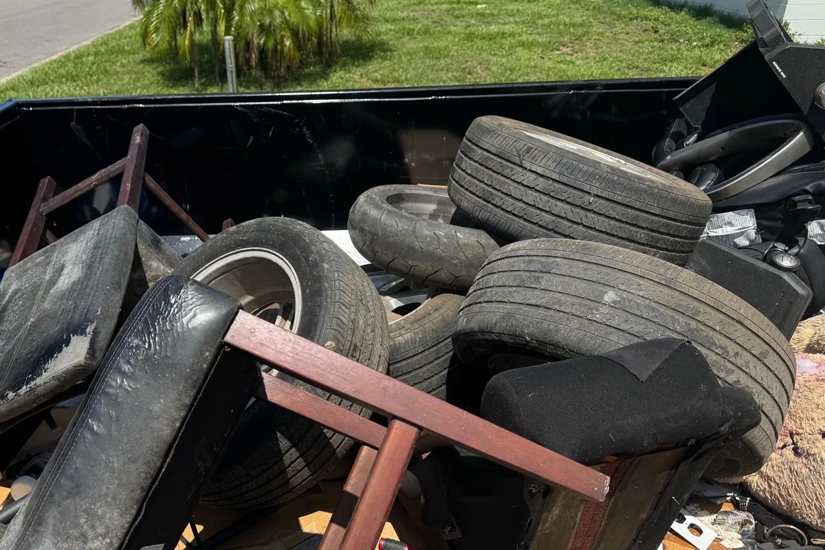 Eco Haul container loaded with tires, a chair frame and upholstery on a residential street